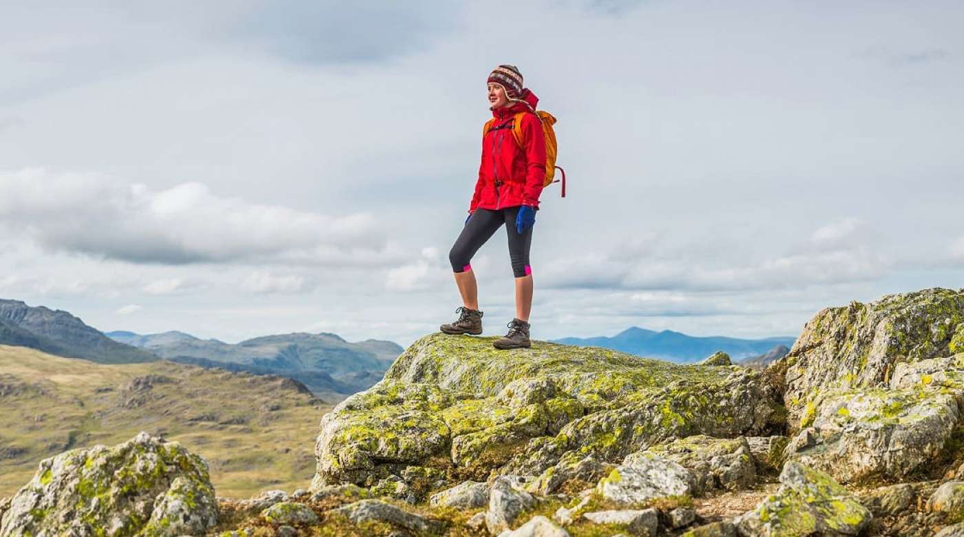 A hiker reaches the summit of a mountain.