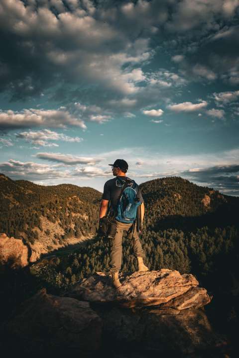 Teen boy looking out over a mountain peak