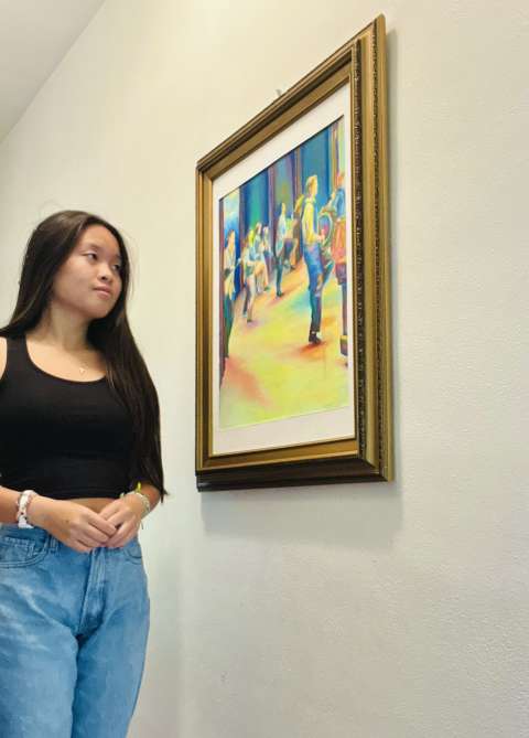 Teen girl staring at a painting on a wall