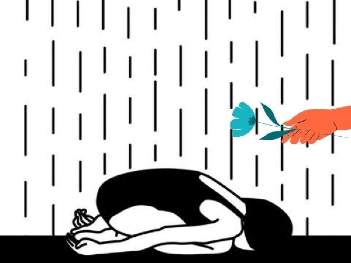 A person lies on the floor in child's pose while a hand extends a flower.